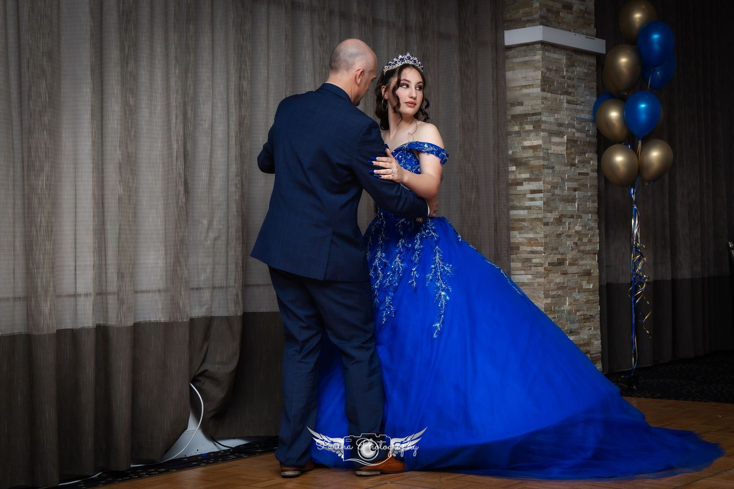 A couple dancing at a formal event with the person wearing a dramatic royal blue ballgown.