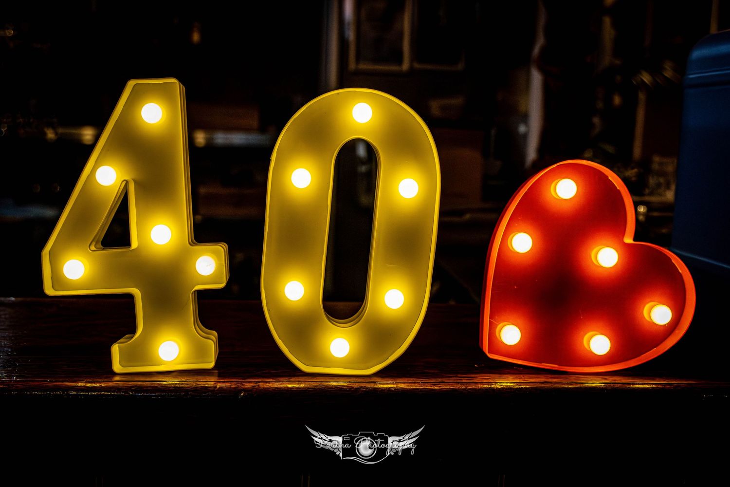 Illuminated numbers spelling out '40' with marquee lights against a dark background.