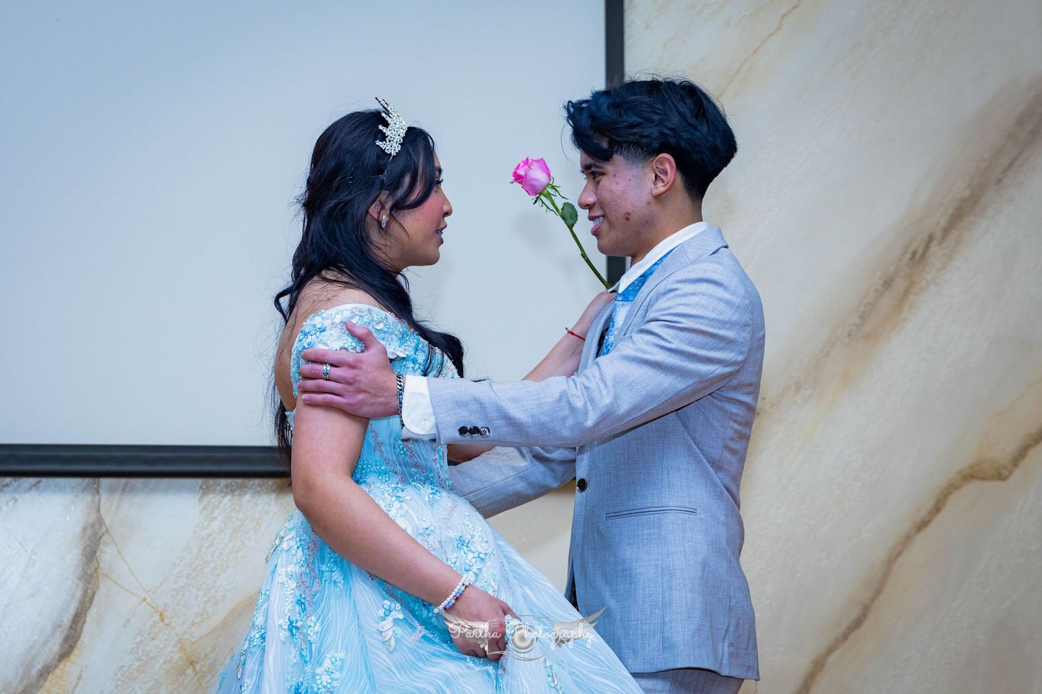 A romantic moment shared between dancers, with one holding a pink rose.
