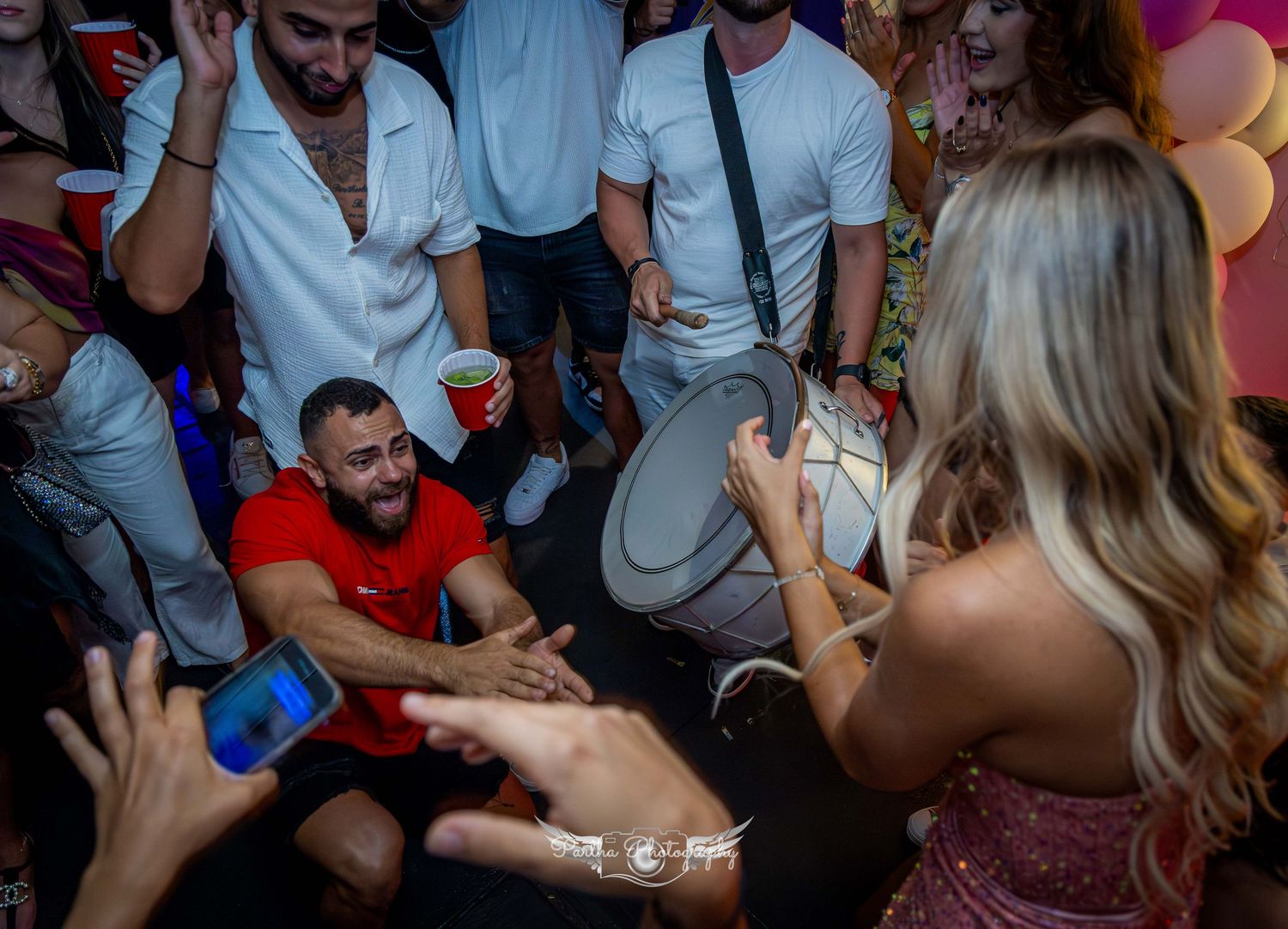 A lively party scene with people dancing and celebrating in a crowded space.