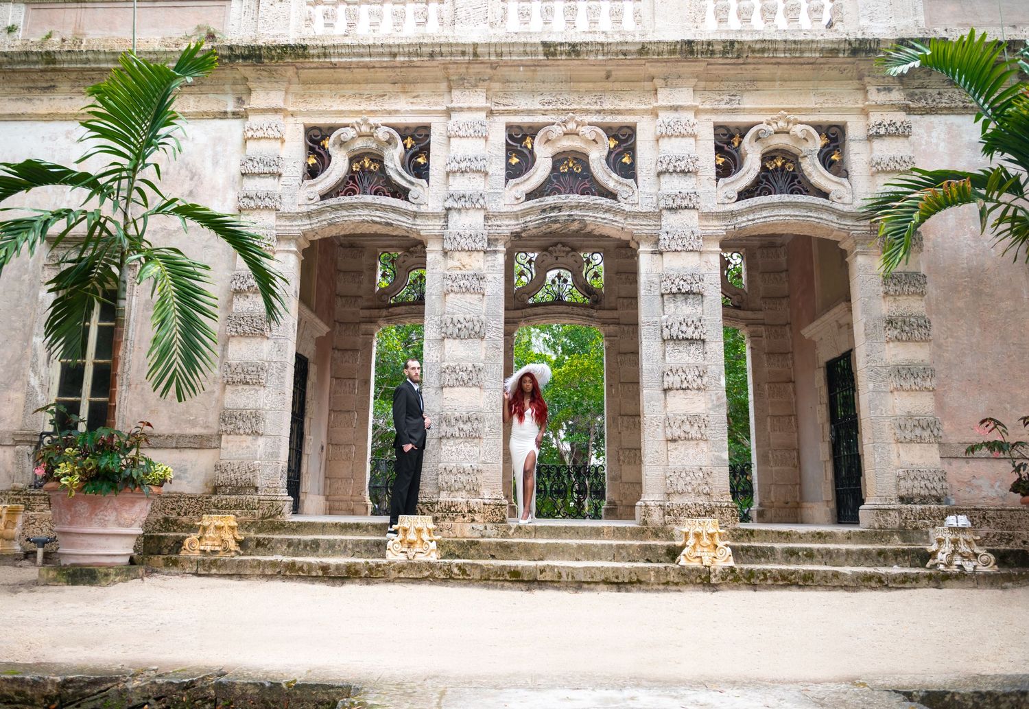 Stylish couple walking past Vizcaya’s reflecting pool, framed by luxury wedding photographers in South Florida.