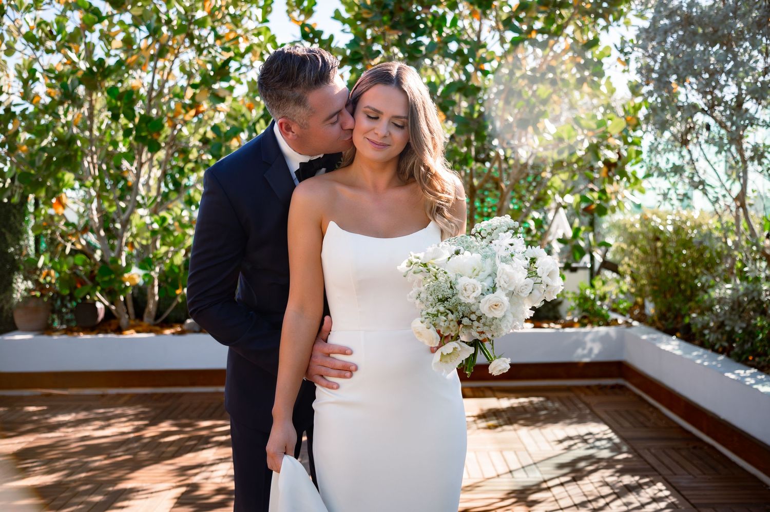 Groom waiting under modern floral arch at The Ray Hotel rooftop, a Florida destination wedding venue