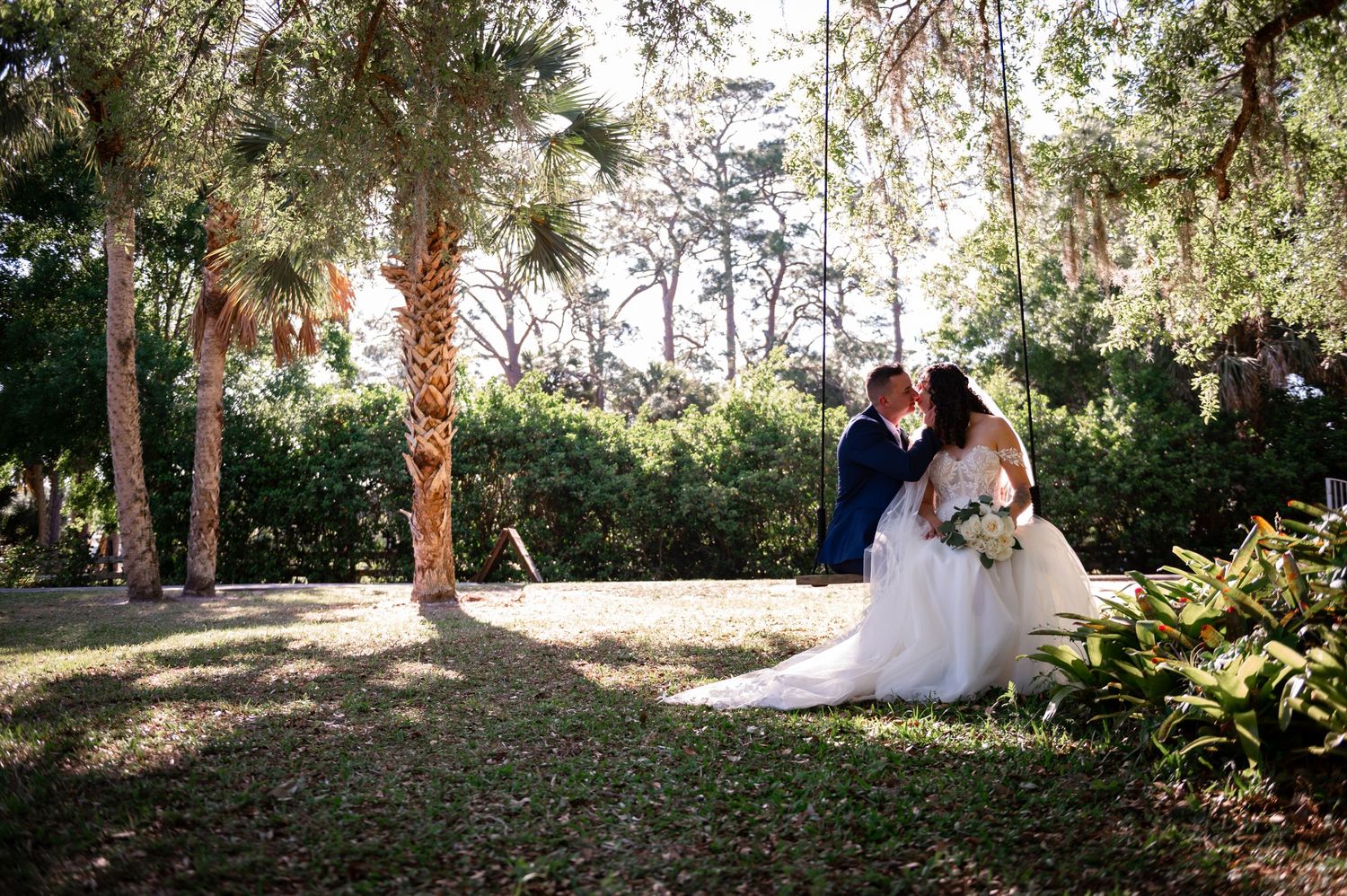 The bride and groom sit together in a swing during the portrait session in Vero Beach, Florida by Treasure Coast Wedding photographers.