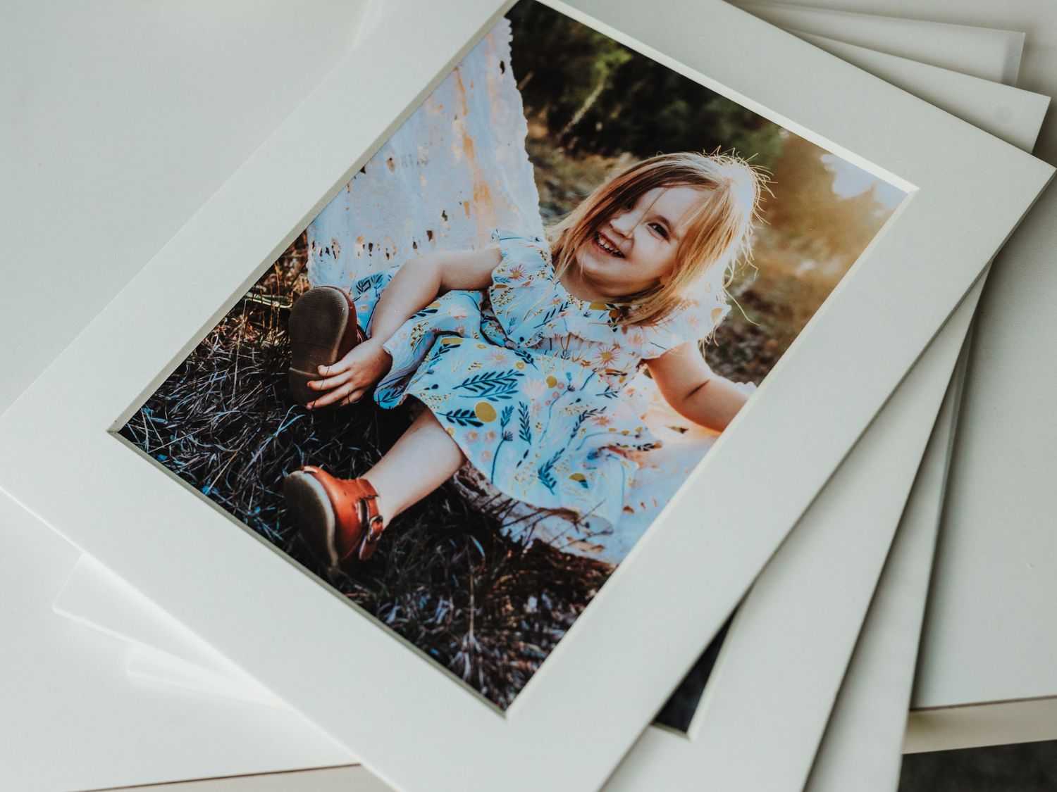 A collection of vintage instant polaroid photos scattered on a white surface with soft lighting.