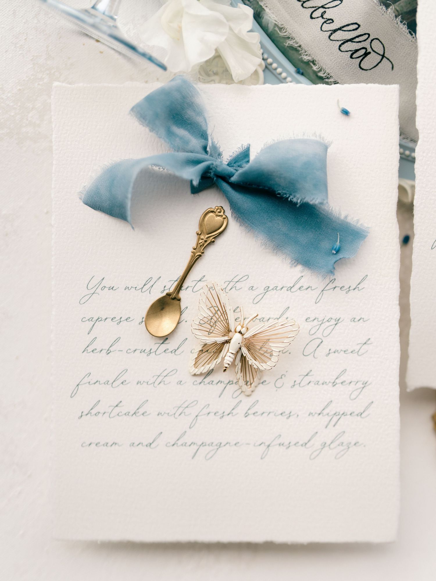 Beautiful wedding stationery with calligraphy text, pale blue silk ribbon and decorative antique gold key accent.