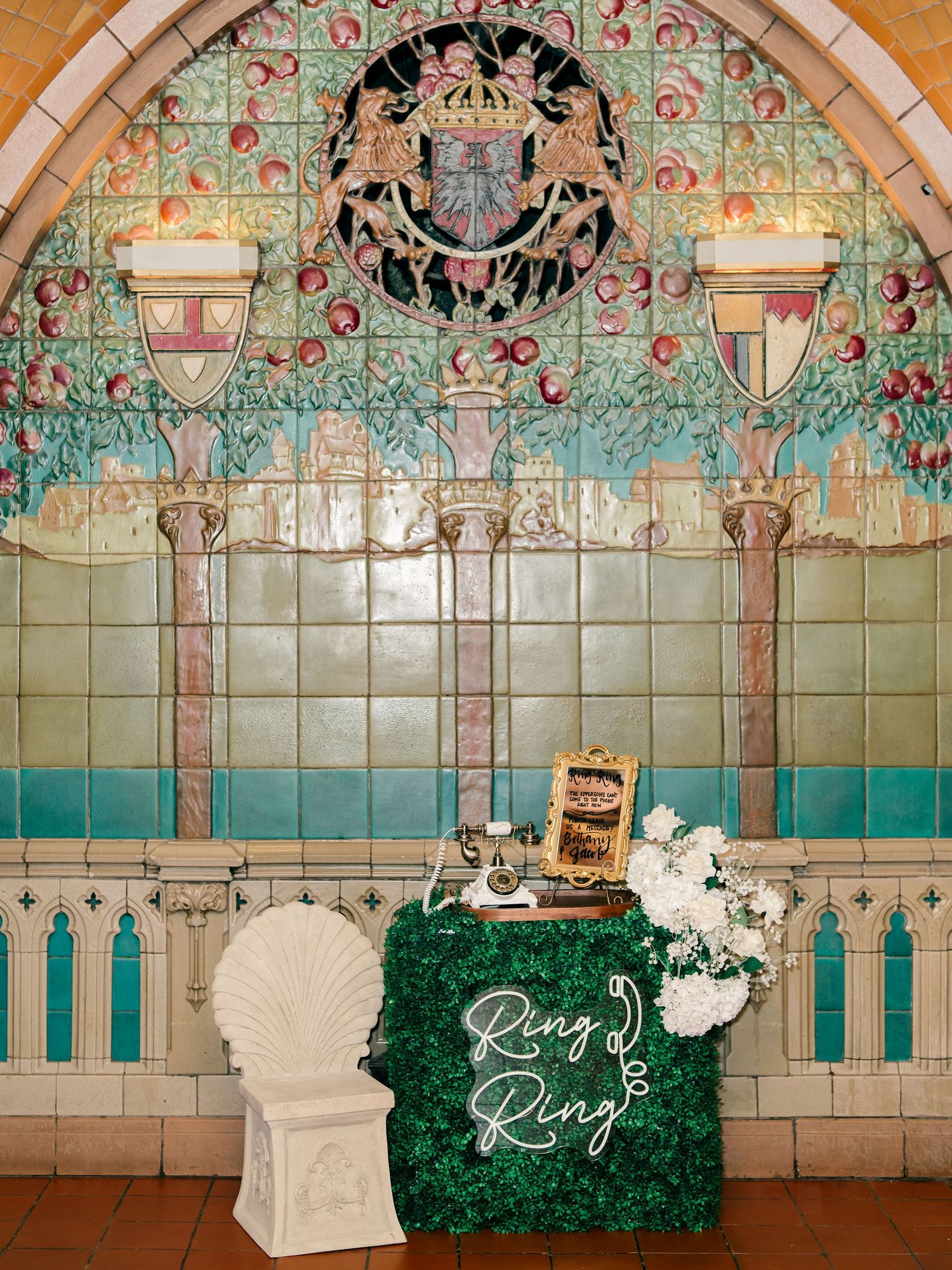 Ornate art nouveau archway with turquoise tiles and floral patterns frames an elegant wedding photo backdrop.