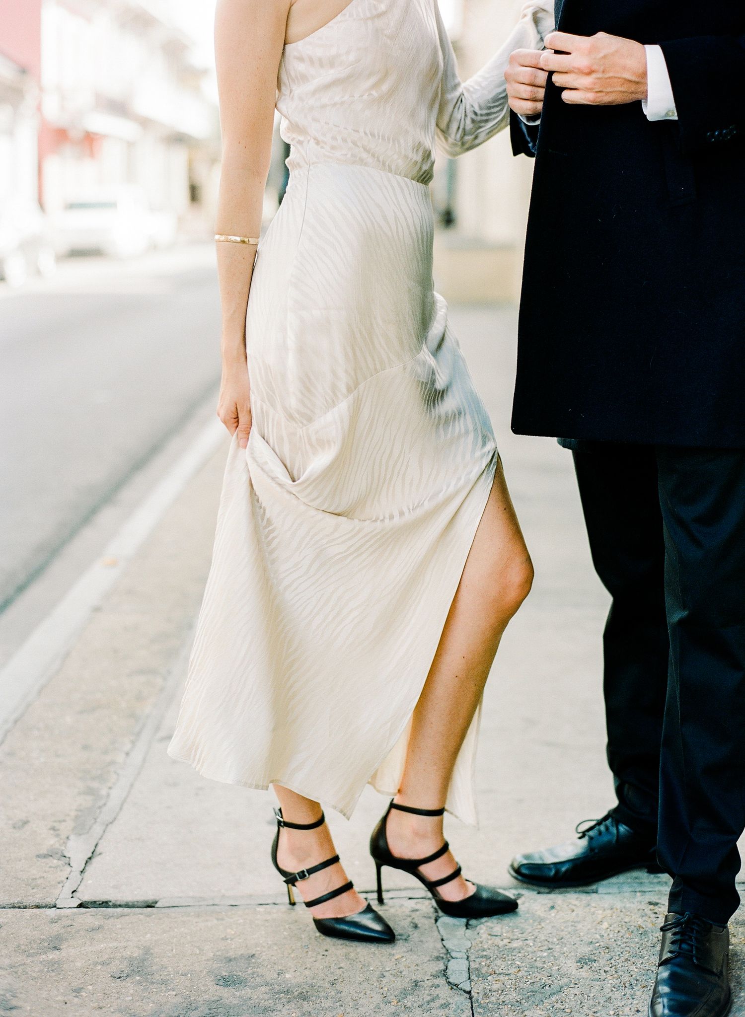 Close up detail of a wedding shoes showing elegant white dress hem and formal black shoes in the French Quarter in New Orleans, Louisiana