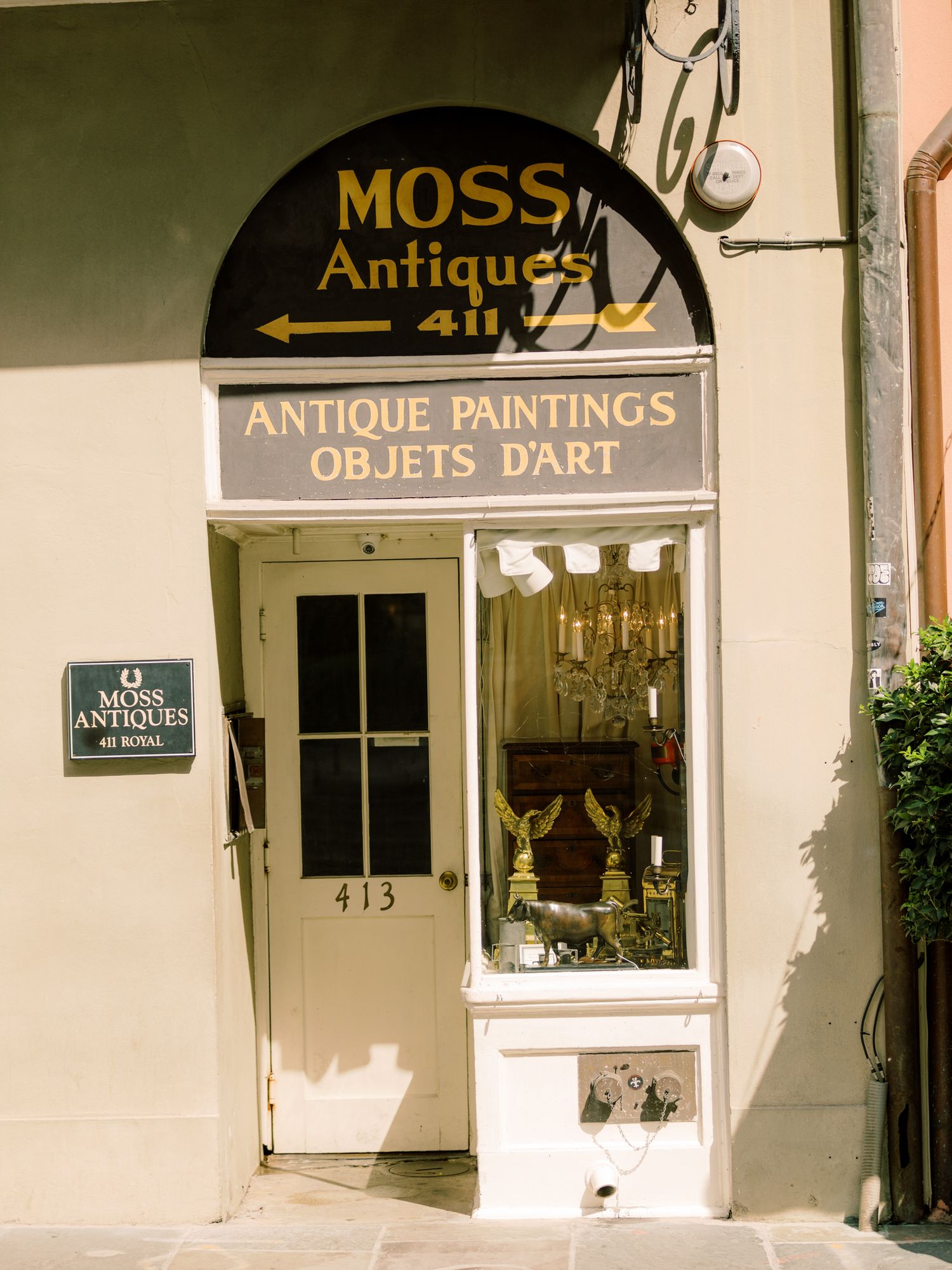 Vintage storefront of Moss Antiques shop with antique paintings and art objects sign in classic architectural style, in New Orleans, LA
