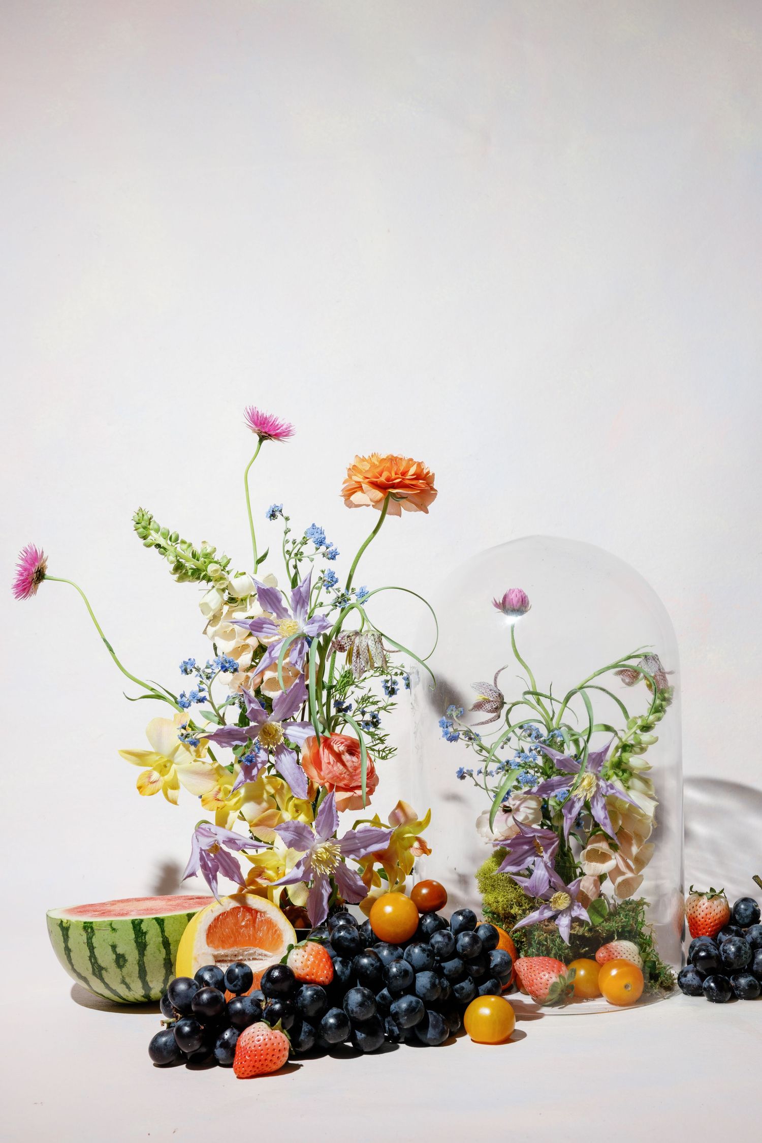 Colorful wildflower still life arranged in vases alongside fresh fruits by New Orleans florist, Sharime Kayla