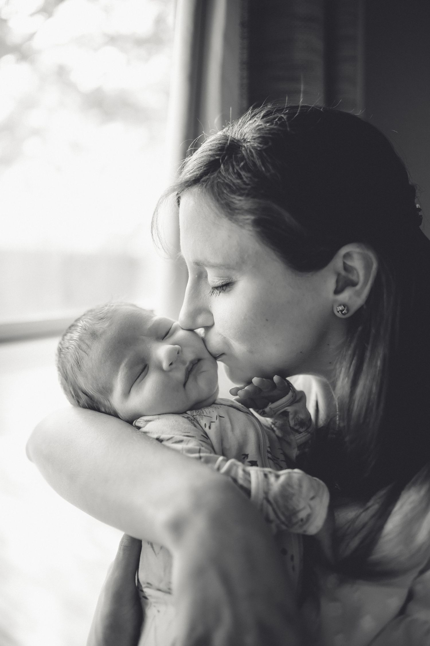 Tender black and white portrait by window light.