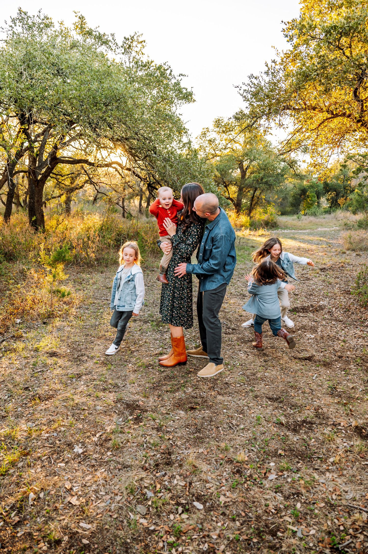 A family enjoys an autumn walk among golden trees on a nature trail.