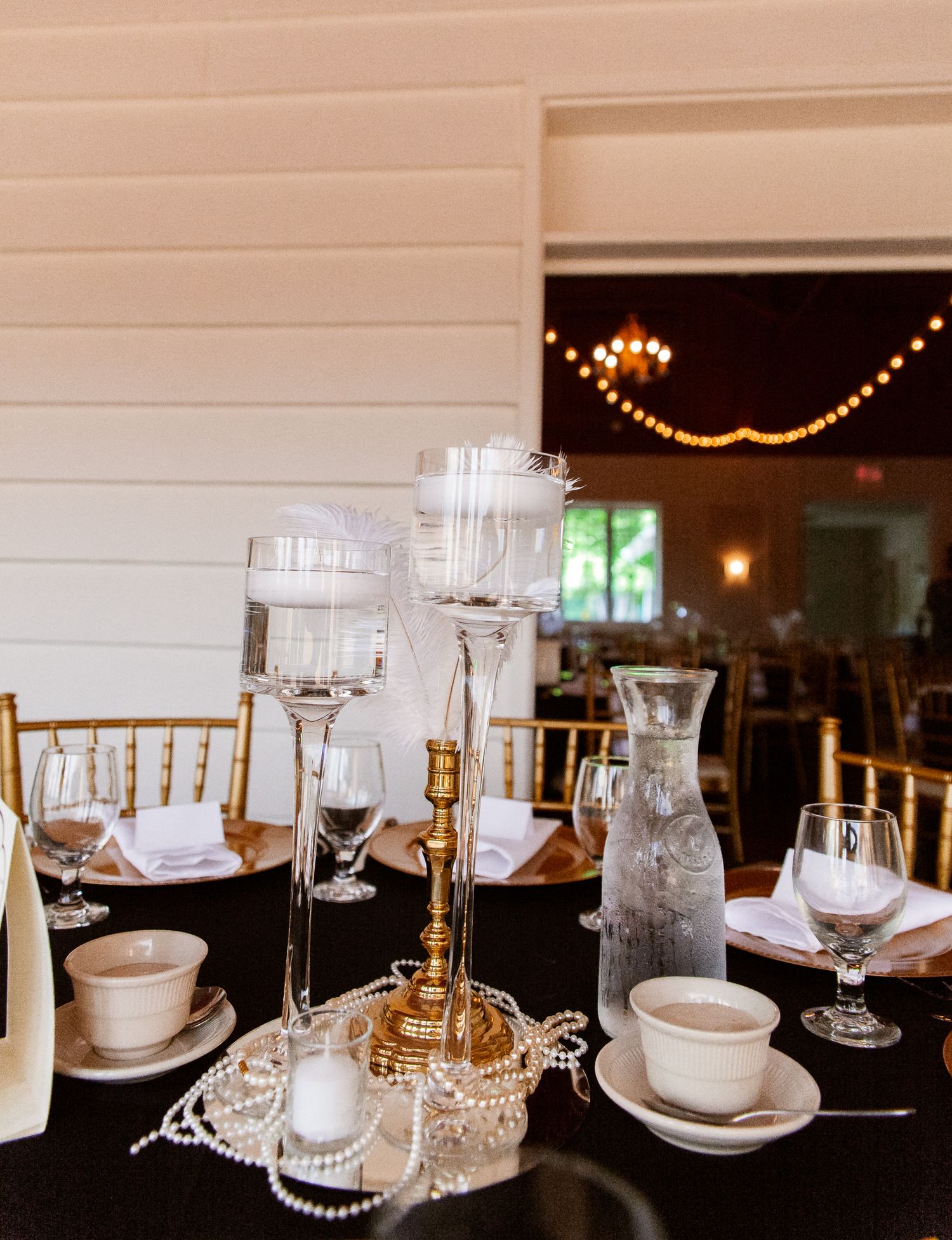 floating white candle gold centerpieces on black tablecloth