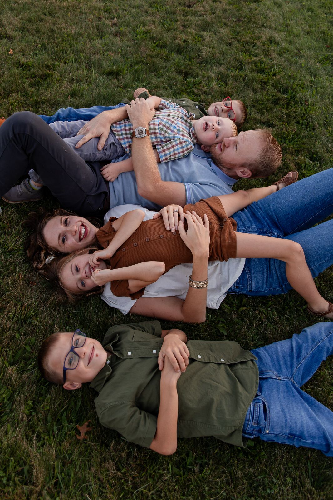 family of six laying on the ground and smiling