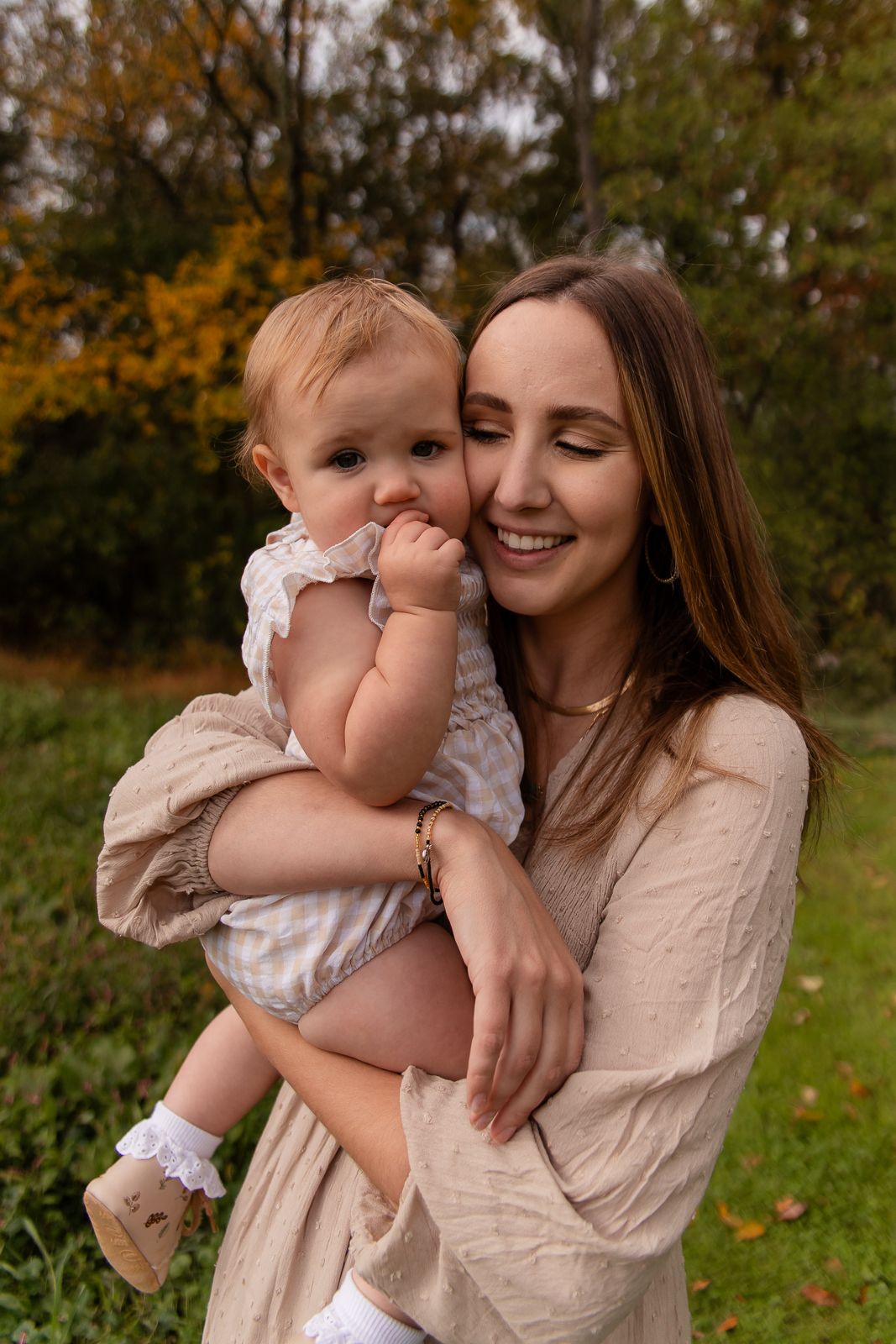 mom and daughter snuggled cheek to cheek in summer outfits