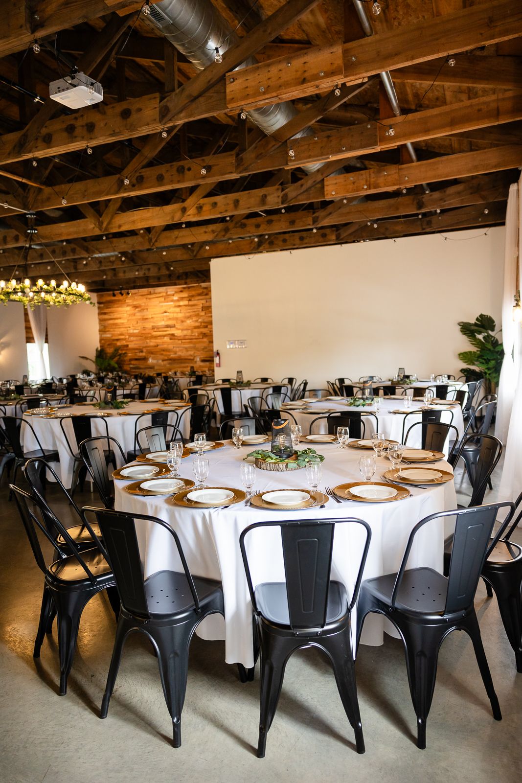 Inside shot of The Monarch Veil reception area with black chair, white tablecloths and fancy place settings