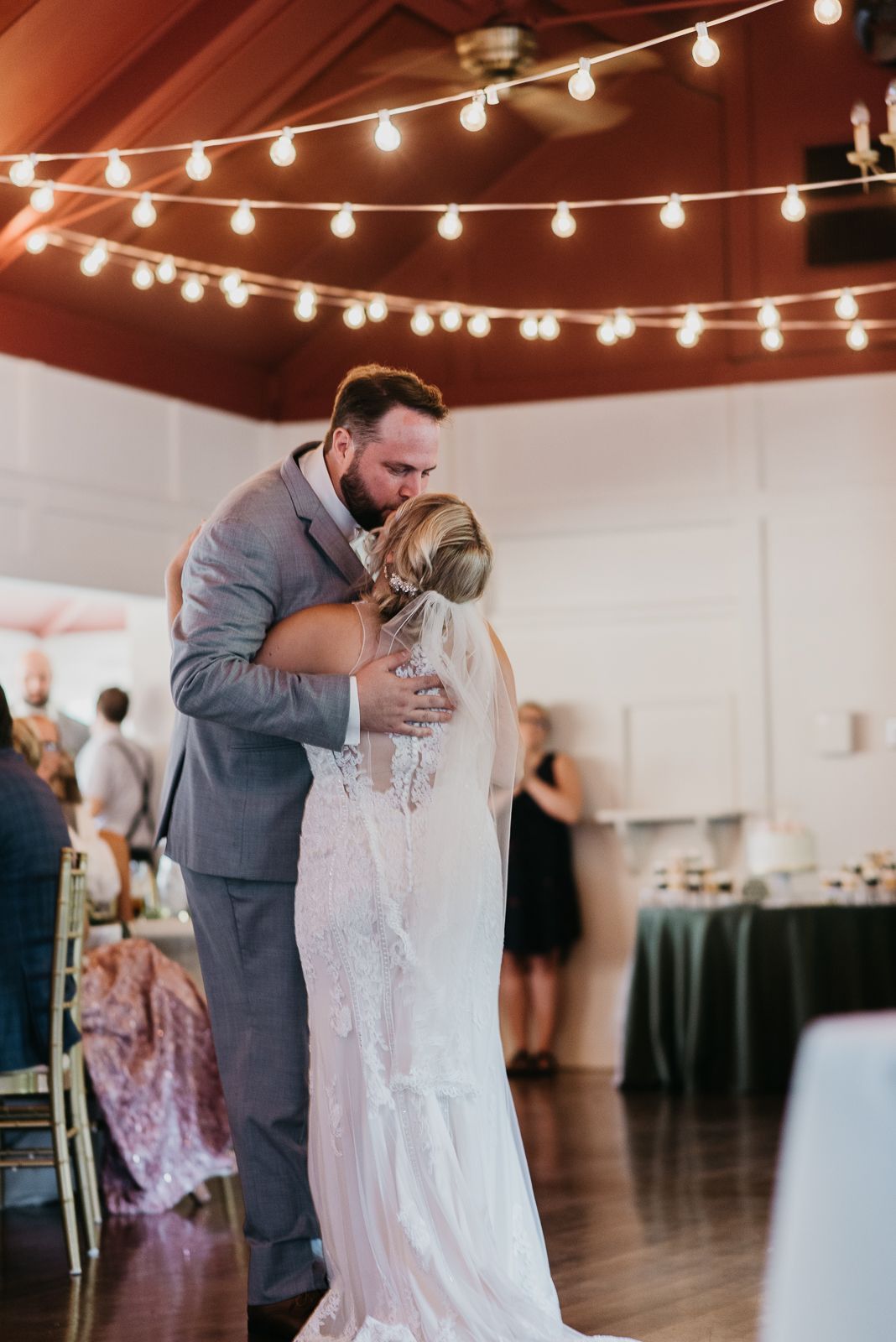 man and woman kissing under twinkle lights at kittanning country club
