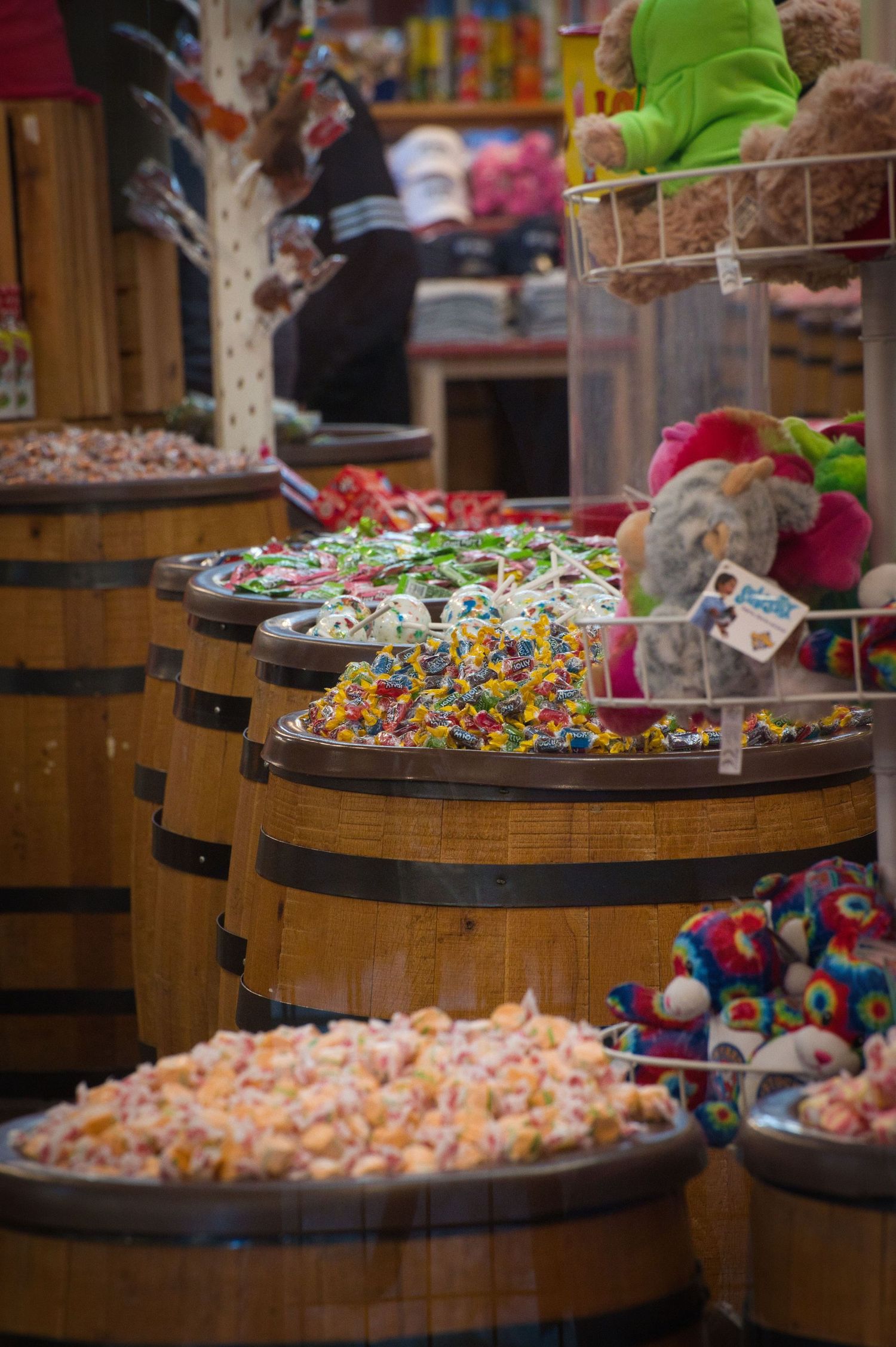 Wooden barrels filled with colorful candy and treats in a retail store display.