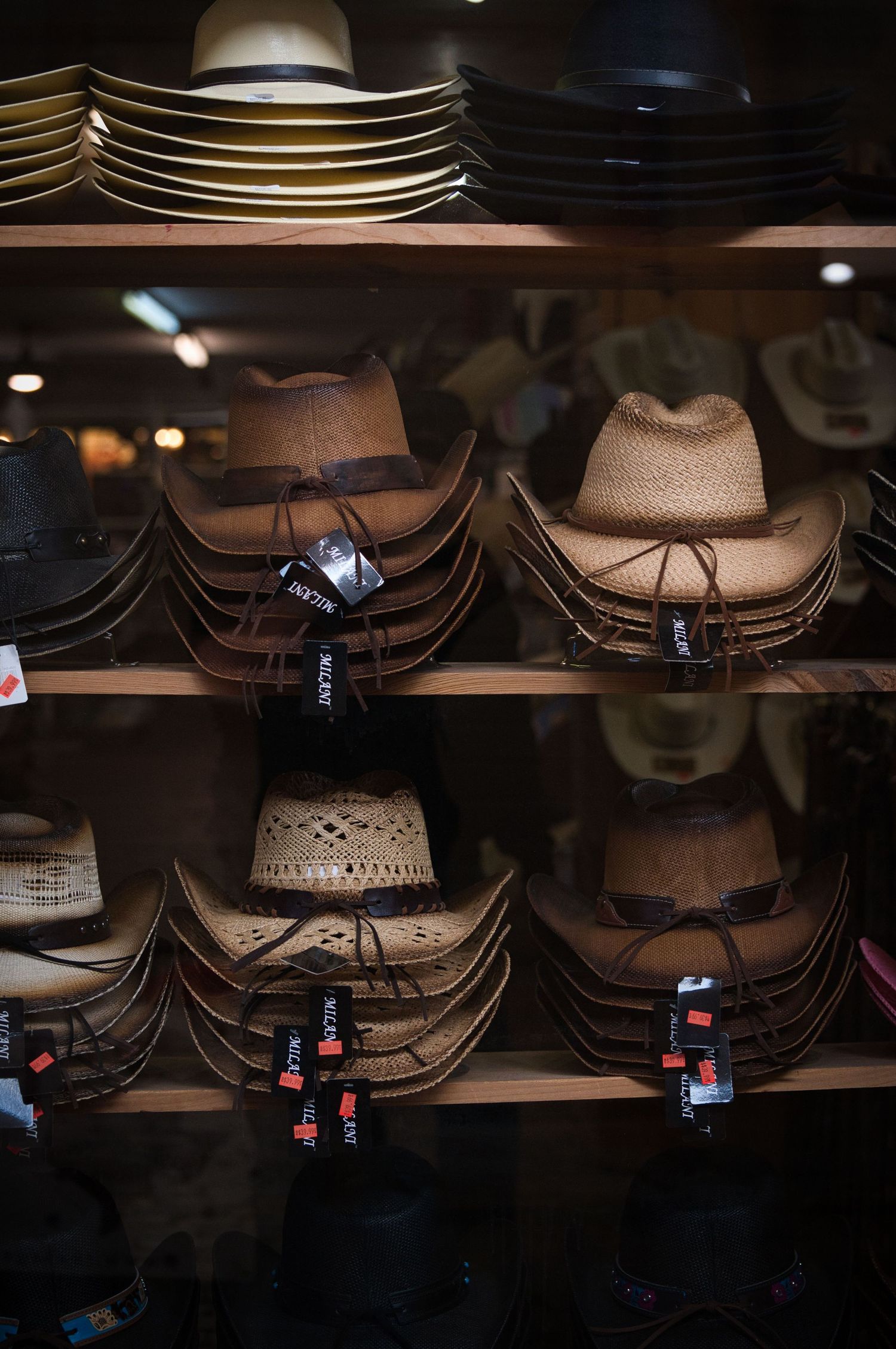 Display shelf stocked with various styles of western cowboy hats for sale.