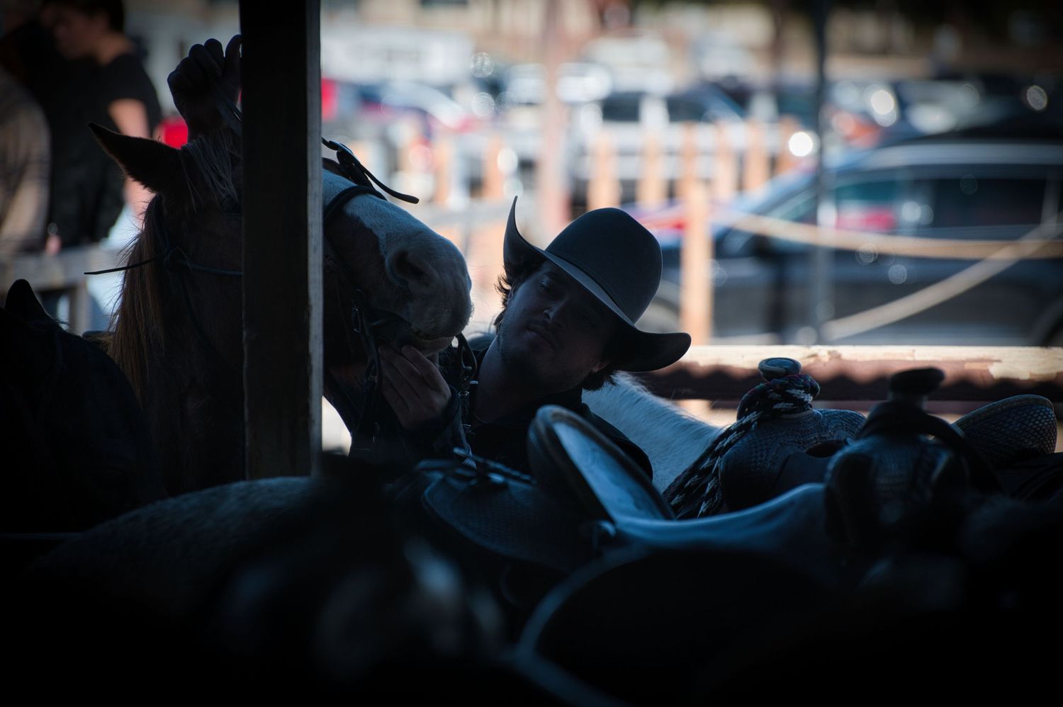 Silhouette of cowboy hat wearing figures in shadowy setting.