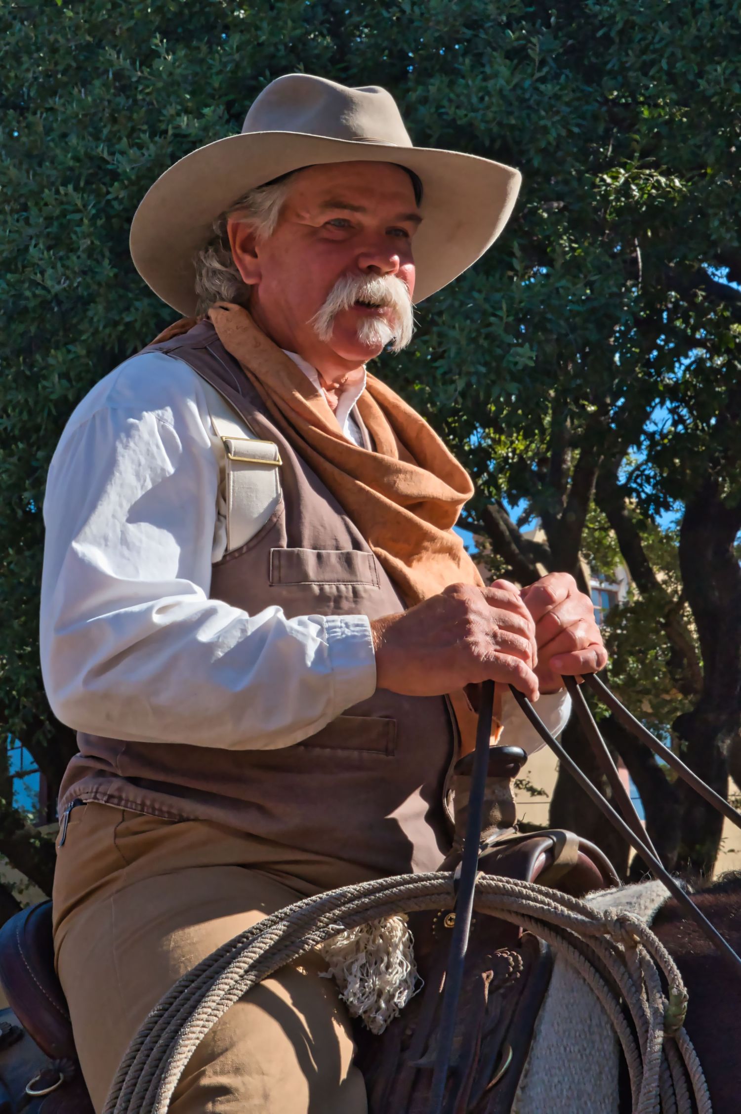 Person in western attire on horseback during a historical reenactment or demonstration.
