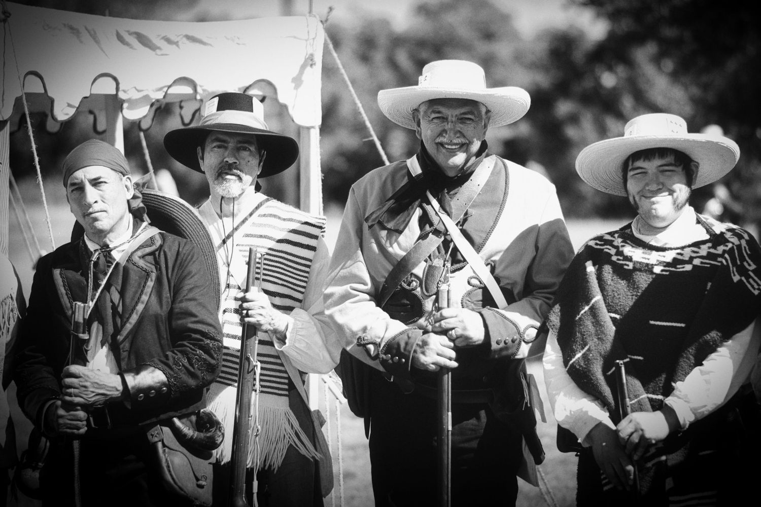 Historical reenactors in War era military uniforms posing with muskets.