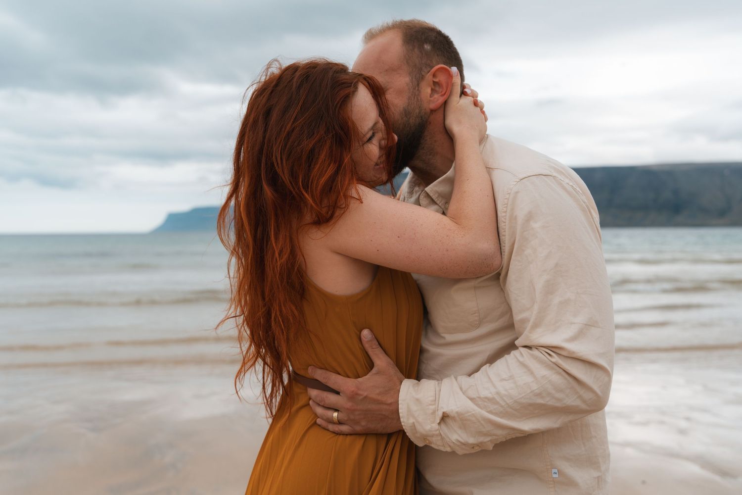 Natalie and Slavek embracing with fjord cliffs in the background