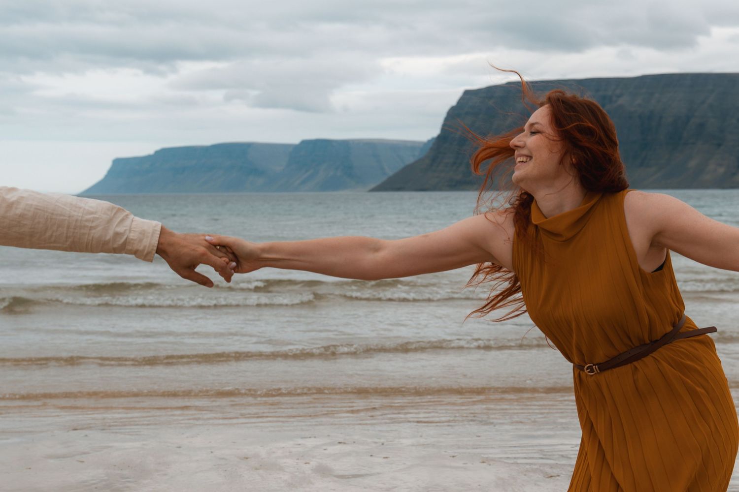 Natalie and Slavek embracing with fjord cliffs in the background