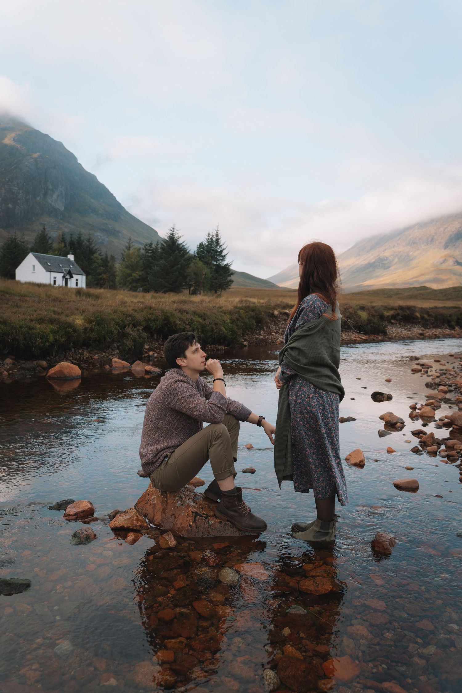 Couple holding hands on a trail in Glencoe mountains at sunset