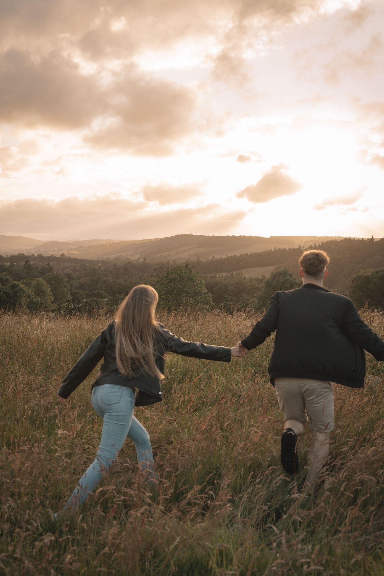 Couple walking through the Scottish Highlands during golden hour