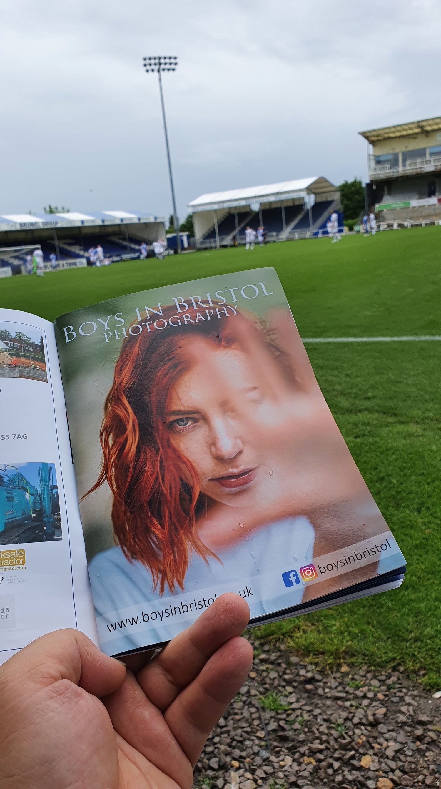 A series of images showing a business card being photographed at a sports stadium with grass fields in the background.