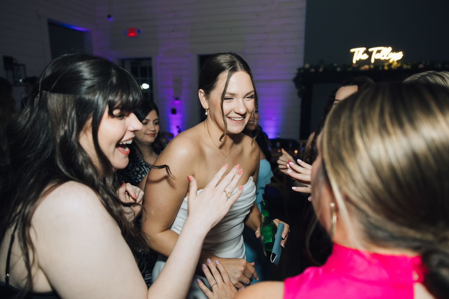 Dance party crowd enjoying nightlife with purple lighting and energetic social atmosphere on the dance floor.