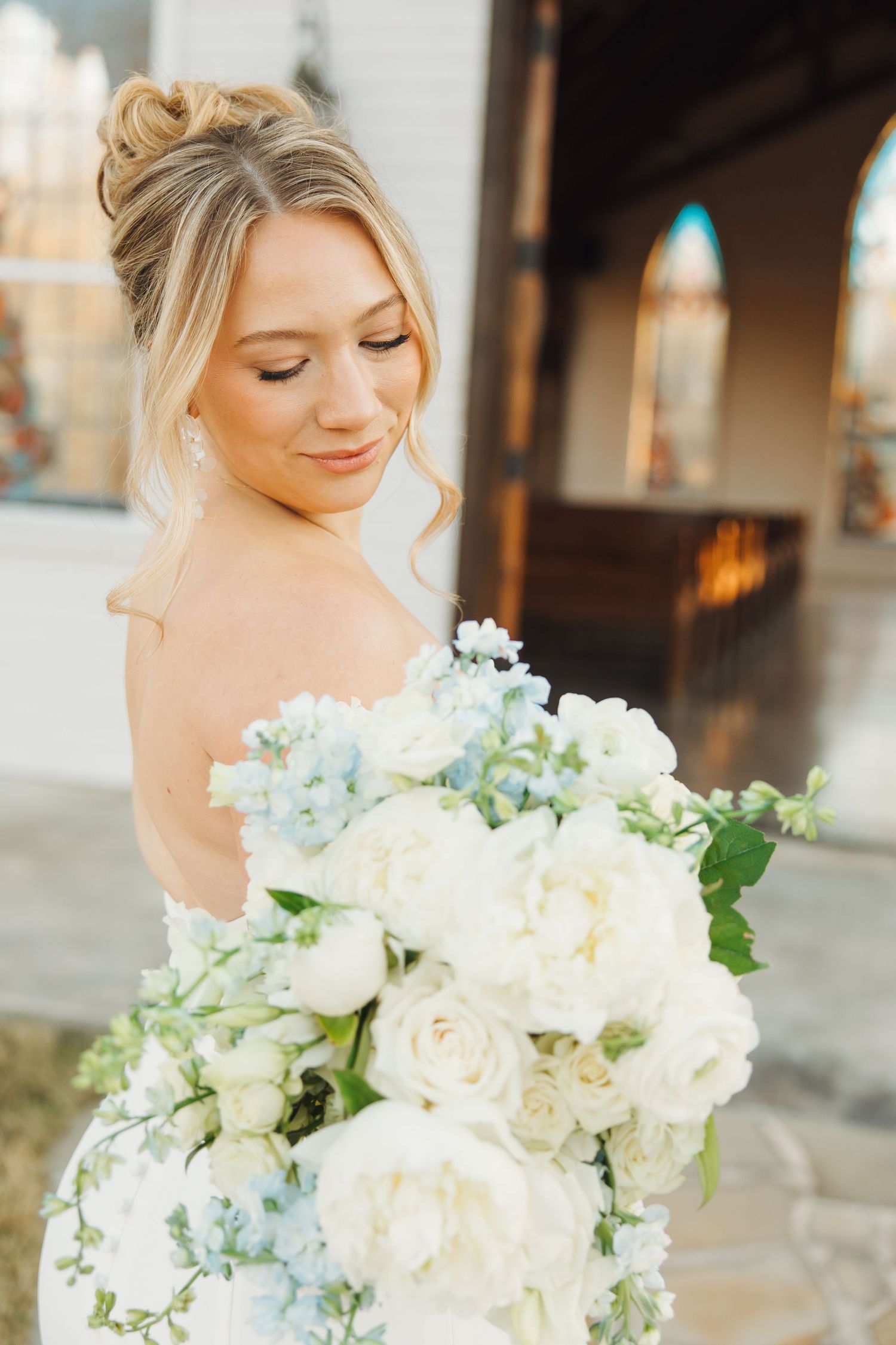 Elegant bridal portraits showing flowing white floral bouquet at a rustic venue.