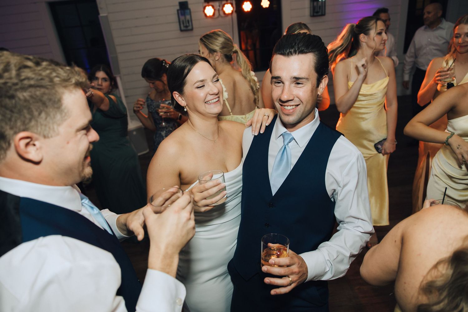 Wedding guests enjoying themselves on the dance floor during a lively reception celebration.