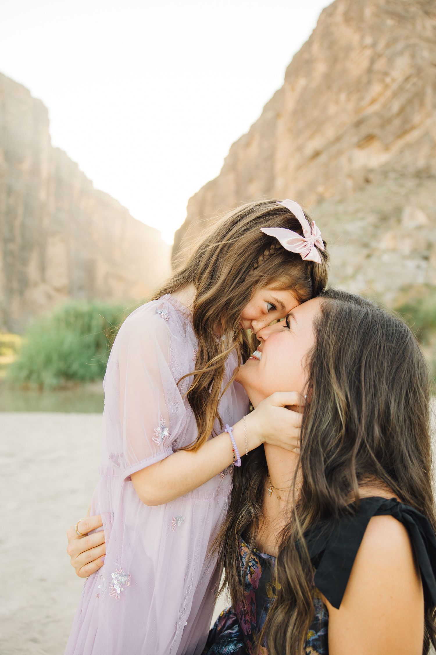 Four progressive photos of an intimate moment shared between two people in flowing dresses against a desert backdrop.