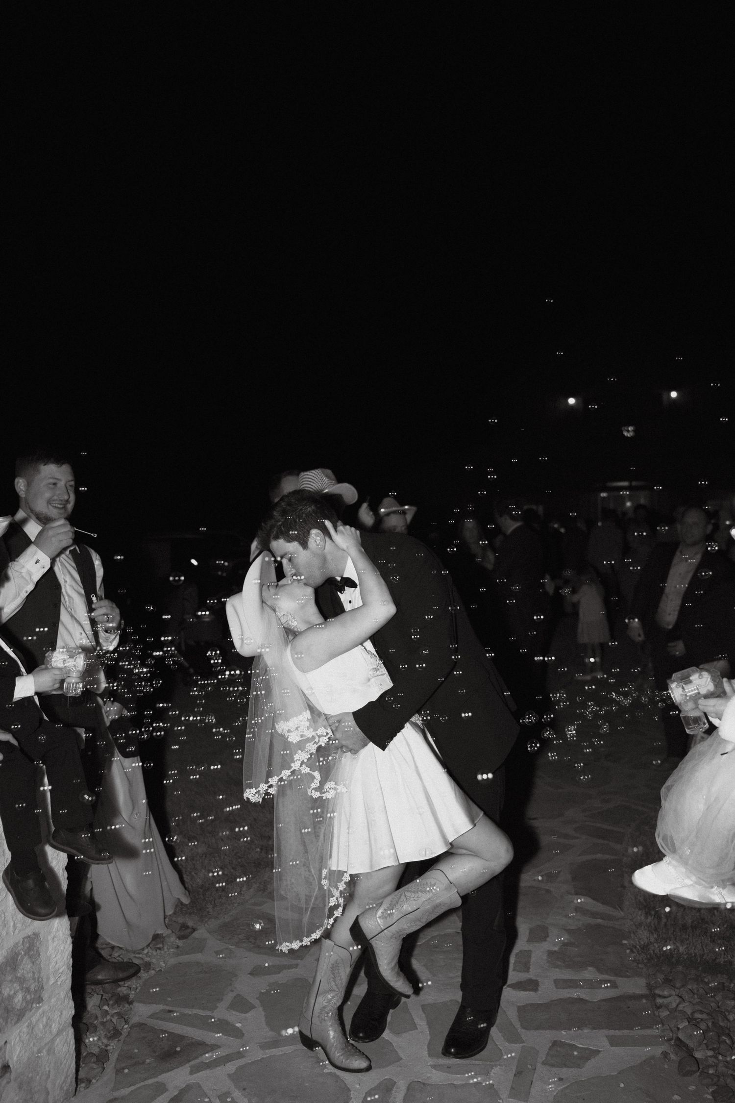 A celebratory dance moment captured in black and white during an evening wedding reception.