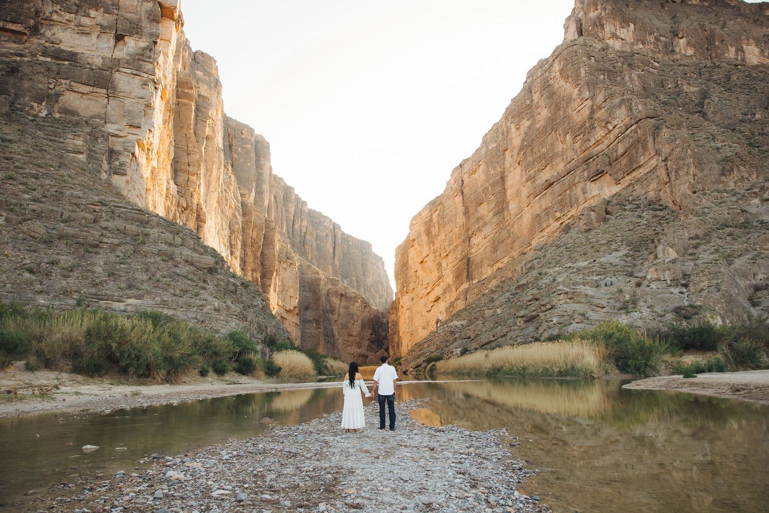 Sunlit limestone canyon walls tower over a winding river path through Santa Elena Canyon in Big Bend National Park.