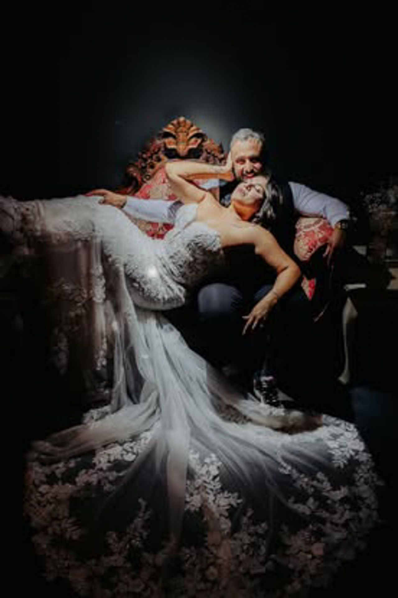 Dramatic black and white photo of couple in formal attire posed in romantic dip position.