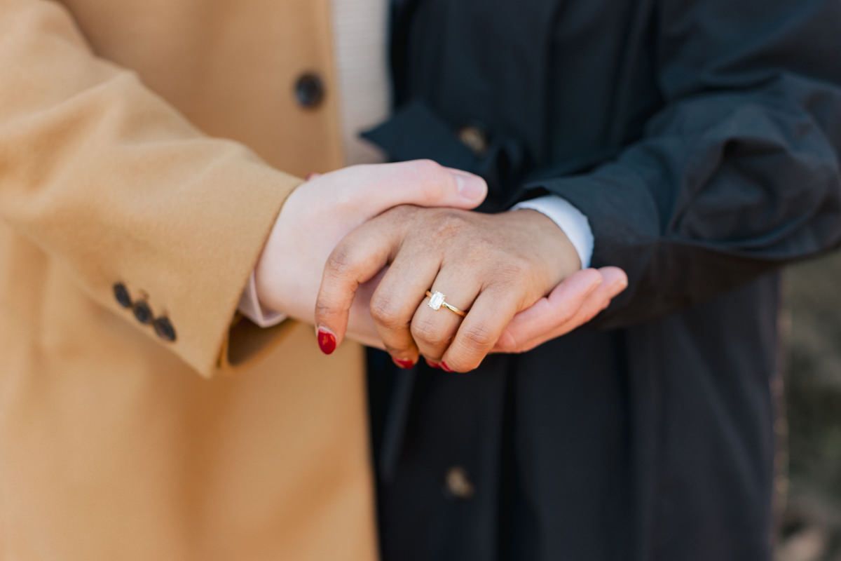 Close-up of two hands holding each other with one person wearing red nail polish.