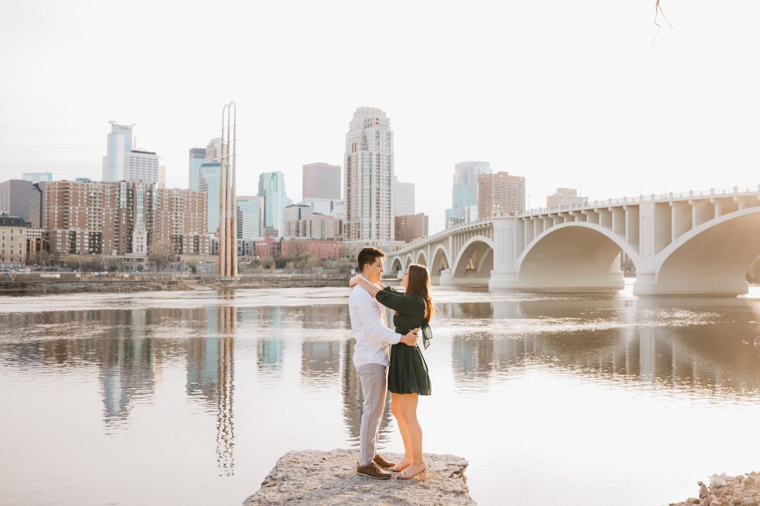 Series of romantic moments photographed along Minneapolis riverfront with skyline views.