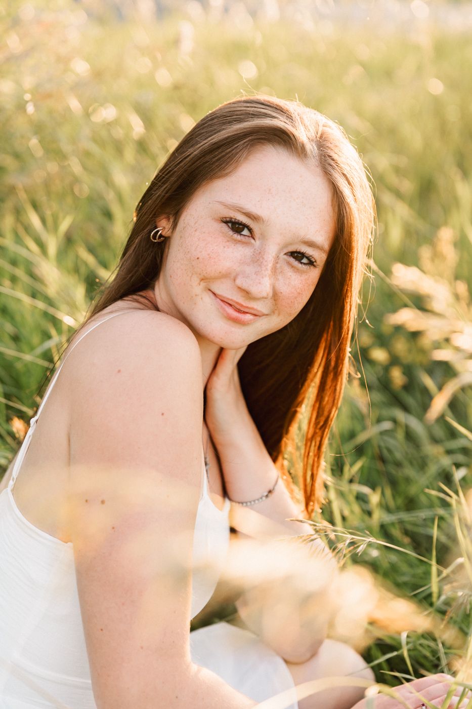 A golden hour portrait in a meadow with sunlit grass.