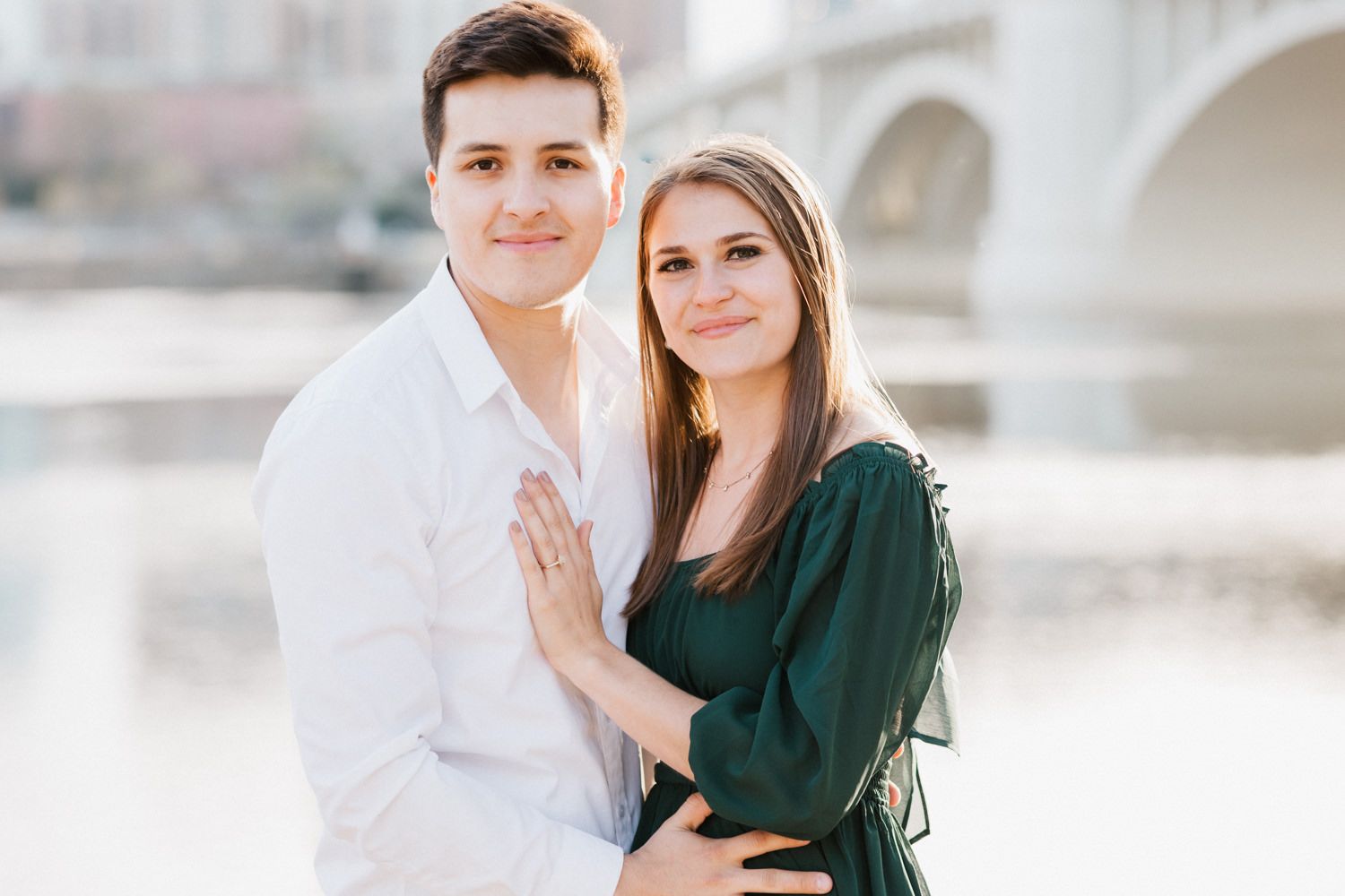 Sweet engagement photos captured along Minneapolis riverfront with iconic bridge view.
