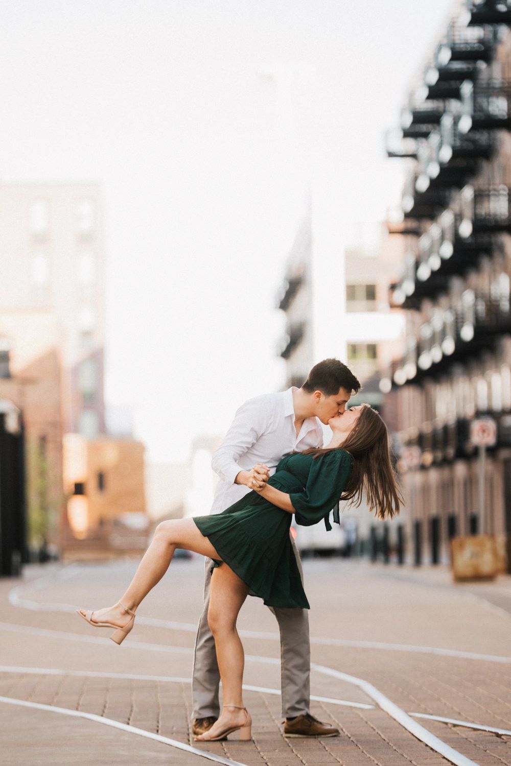 Romantic couple dancing in urban setting at sunset.