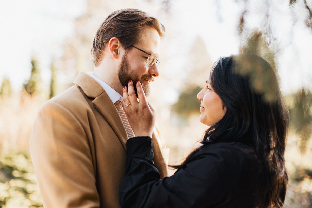 A tender romantic moment captured between a couple in warm sunlight.