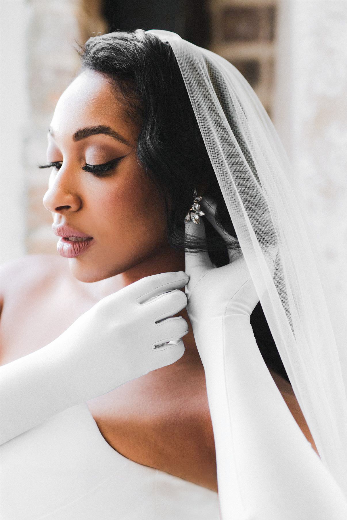 Close up film photograph of a bridal portrait of a black women putting on her earrings in the Lehigh Valley, PA