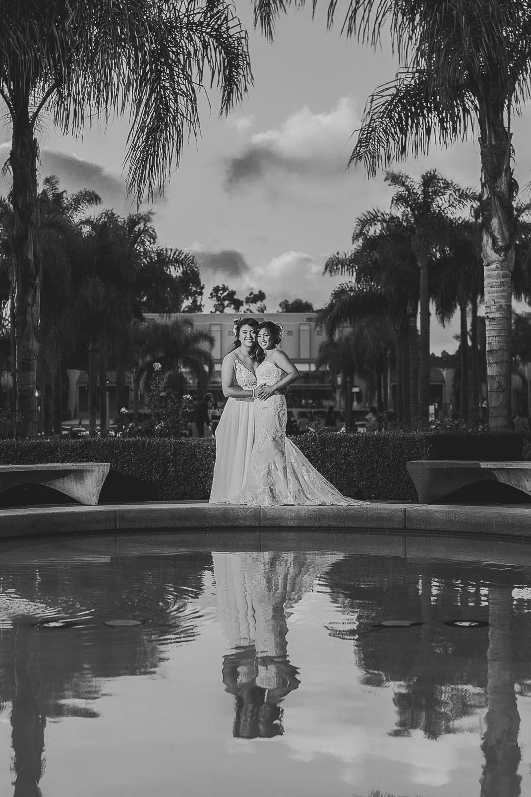 Queer Wedding in Pennsylvania. Two brides holding each other in reflection of pool after wedding in black and white