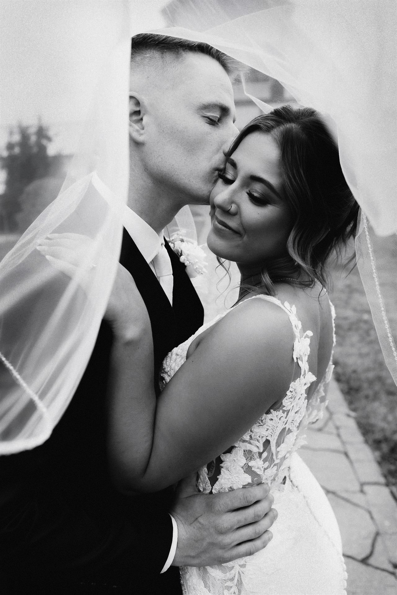 Intimate documentary-style photo of a couple sharing a tender kiss, captured on film with soft natural light and a timeless, cinematic feel