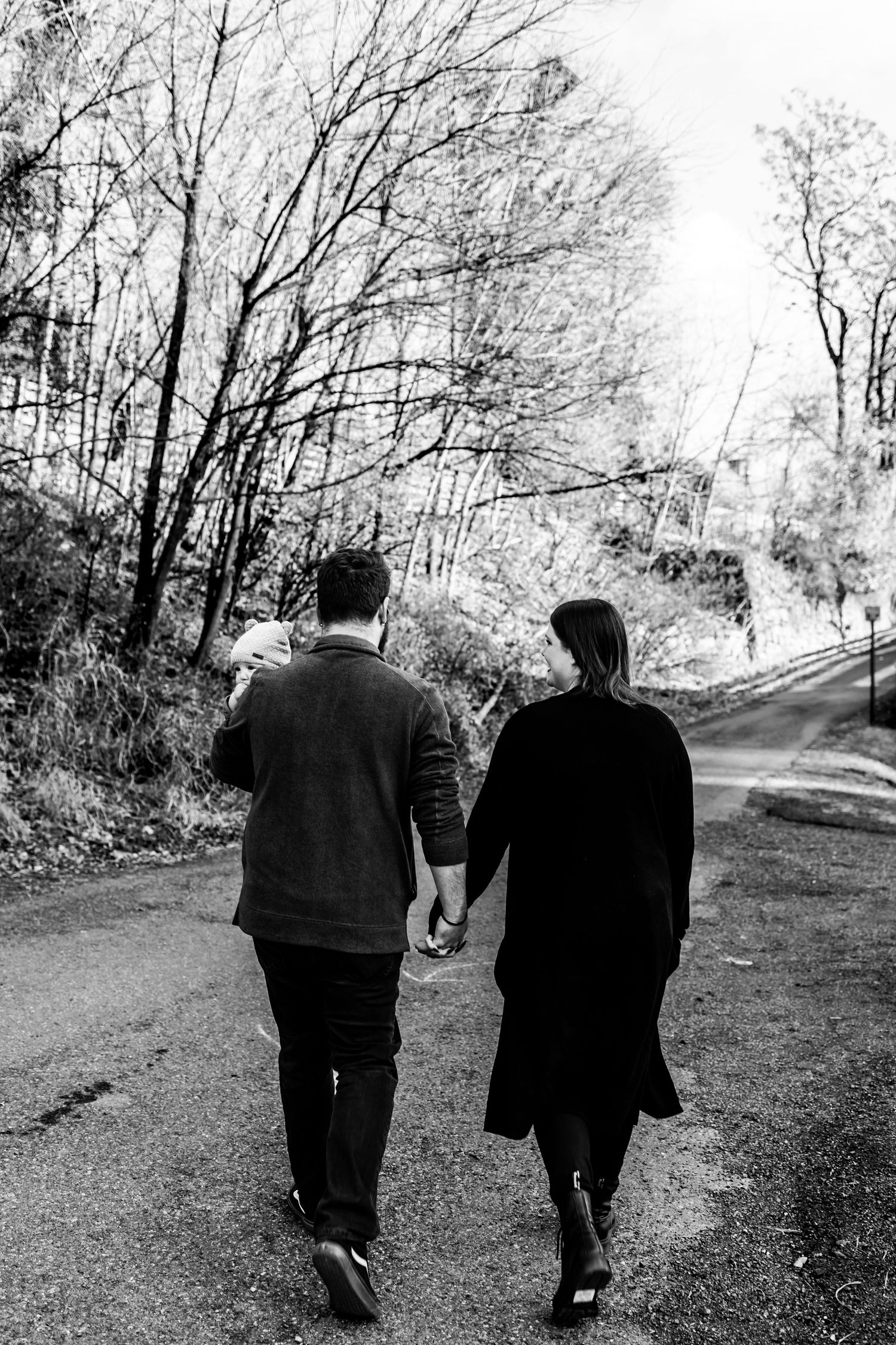 Man and Woman holding two children and walking away in black and white