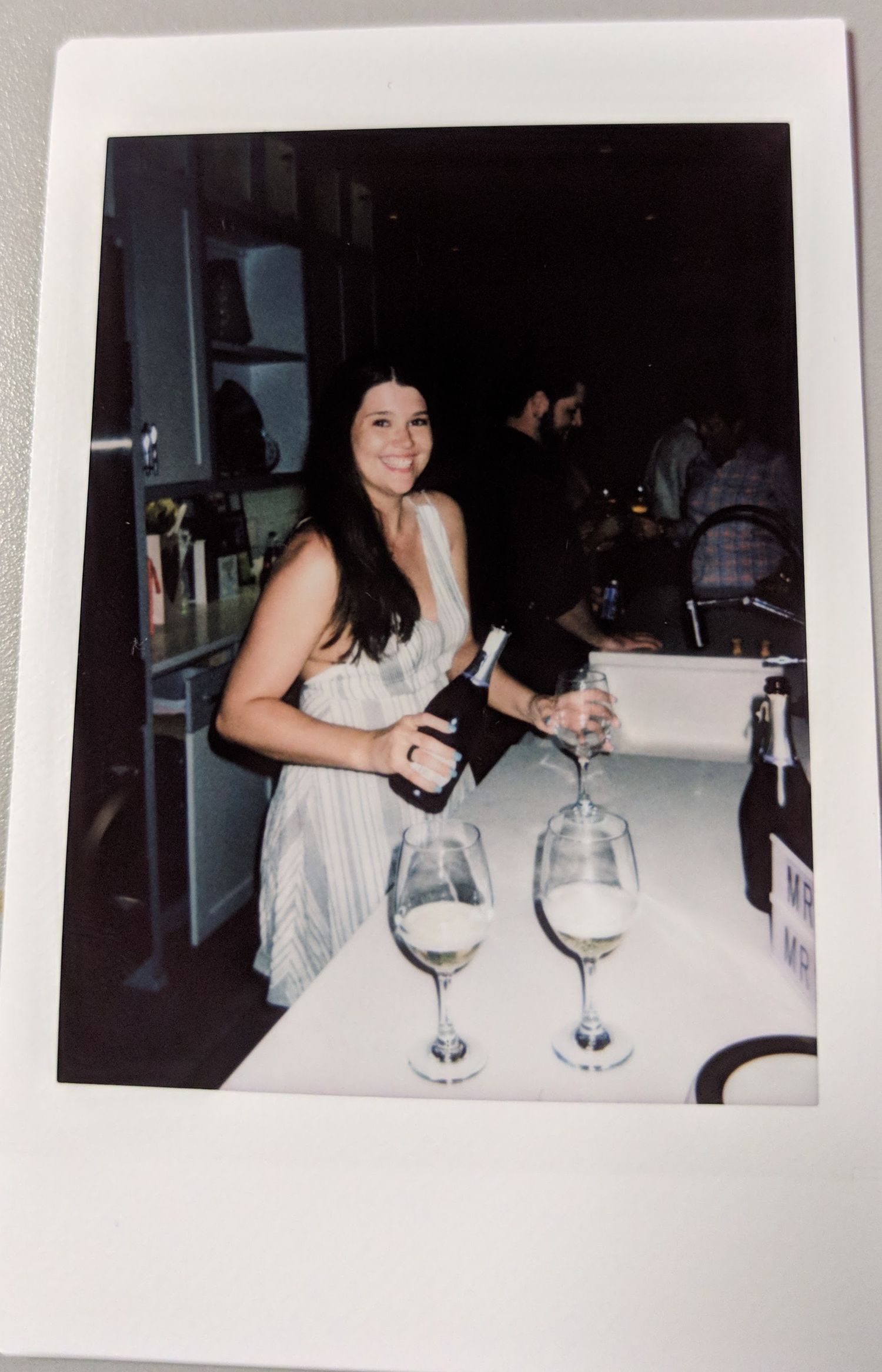Picture of a bride pouring wine at a large table. Film photograph in Destin, FL