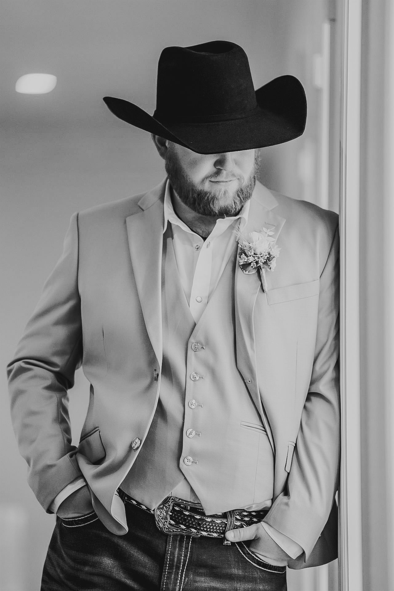 Groom adjusting hat before ceremony in Birmingham AL, editorial prep photo in muted green tones
