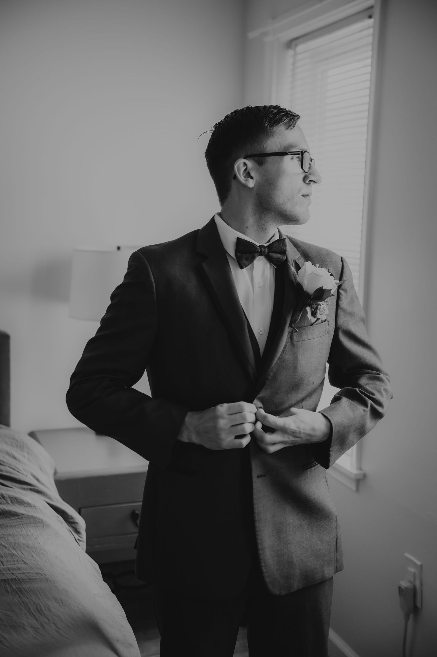 Groom adjusting tie before ceremony in Easton, PA. Editorial prep photo in black and white.